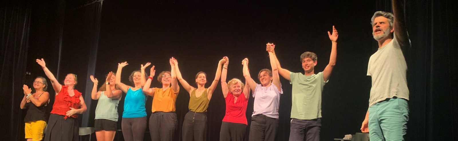 Groupe d'improvisateurices saluant le public d'un théâtre